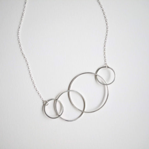 Four sterling silver loops on adjustable silver chain.