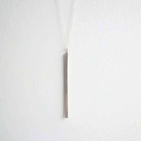 A 4cm long bar of solid silver hangs on a fine sterling silver chain