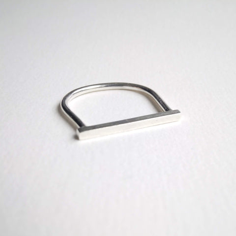 A solid sterling silver bar on a sterling silver band makes this ring look like a horse stirrup.
