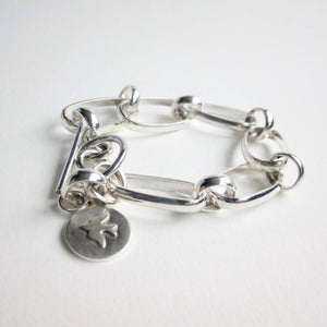 Made with 3x1.5mm half round wire. Secured by a toggle closure. Made with .925 sterling silver