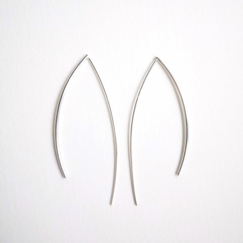 sterling silver round wire arcs hang 6cm from the ear. Pebble around 4-6mm