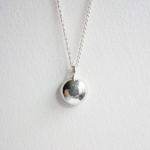 Solid sterling silver pebble, hangs on a fine sterling silver chain. Pebble around 8-10mm